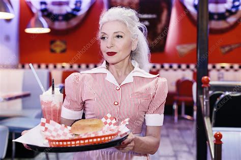 A hamburger (also burger for short) is a sandwich consisting of one or more cooked patties of ground meat, usually beef, placed inside a sliced bread roll or bun. Mature female waitress serving burger in 1950's diner - Stock Image - F020/8461 - Science Photo ...