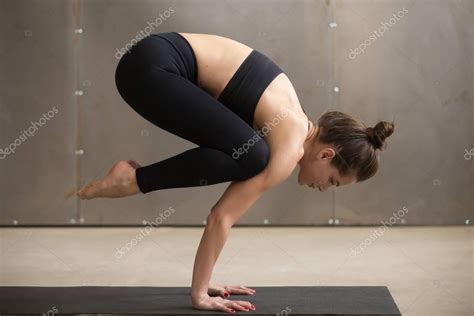 All our images are transparent. Young attractive woman standing in Bakasana pose, grey ...