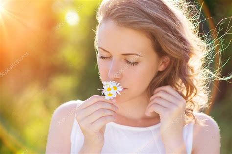 Flowers have different meanings depending on their color. Kvinna att lukta blommor på en äng. — Stockfotografi ...