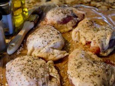 Close up shot of a chicken thigh in a casserole dish. How to Bake Boneless Chicken Thighs | eHow