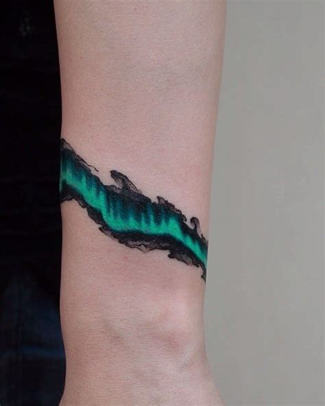 See more ideas about disney tattoos, tattoos, aurora tattoo. Green aurora tattooed around the left wrist by Evgeny Mel ...