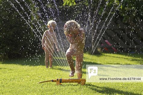 Gerade garten und balkon entpuppen sich oft als auslöser für streit unter nachbarn. Kinder spielen mit Sprinkler in Garten - Lizenzfreies Bild ...