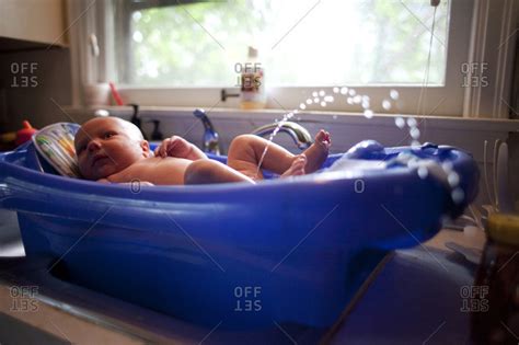 A baby bathtub can help prop up your wriggling newborn and make bath time safer and more enjoyable for everyone. A baby boy urinates during a bath stock photo - OFFSET