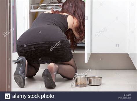 We have more than 324 videos with daily updates. woman bent over in the kitchen looks in a cabinet ...