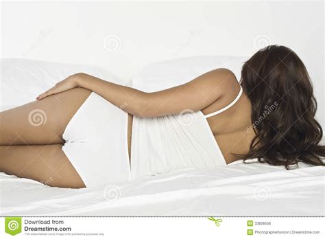 Lying in bed next to a man is a symbol of unexpected news. Young Woman Lying In Bed stock photo. Image of people ...